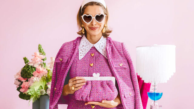 Image of Lele Sadoughi holding a pink clutch purse